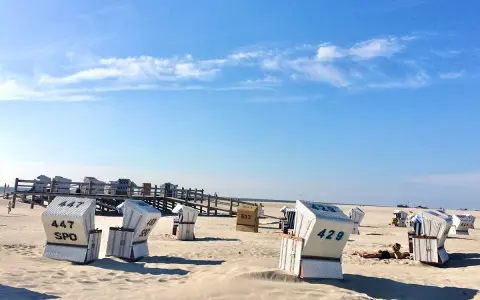 Strandkörbe am Meer, ein Geheimtipp für Sankt Peter-Ording. Sonnenschein und blauer Himmel.