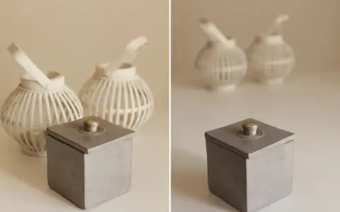 Boîte grise avec couvercle orné d'un bouton argenté, lanternes blanches en arrière plan avec un flou arrière plan artistique.