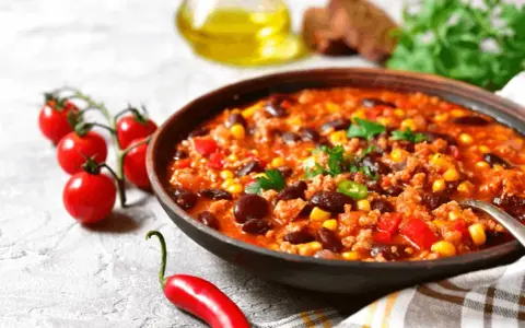 Miska sycącej zupy meksykańskiej z fasolą, kukurydzą i mielonym mięsem. Idealne jakie przyprawy do zupy meksykańskiej? Chili, kumin, papryka.