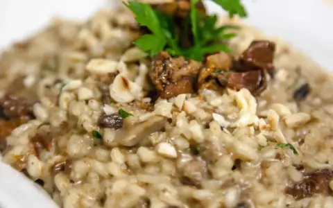 Cremoso risotto de boletus con trozos de champiñones, nueces picadas y perejil fresco.