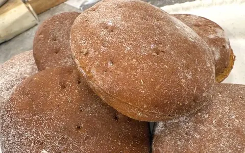 En hög med nybakade rågkakor, perfekta för ett enkelt rågkaka recept. Strödda med lite mjöl.