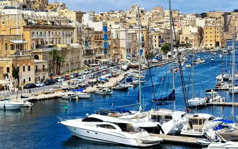 Malta blog: maltański port pełen jachtów i łodzi, z malowniczymi kamiennymi budynkami w tle.