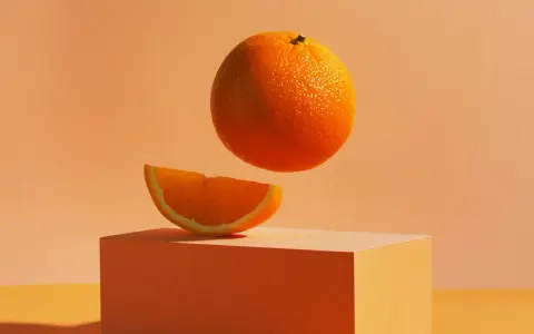 Pomarańcze na keto – soczysty plasterek na pomarańczowym sześcianie, a nad nim lewitująca cała pomarańcza.