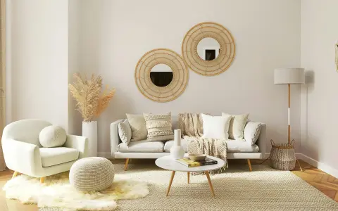 Un salon boheme nature avec un fauteuil douillet, un canapé confortable, des coussins texturés, des miroirs en rotin et des herbes séchées.