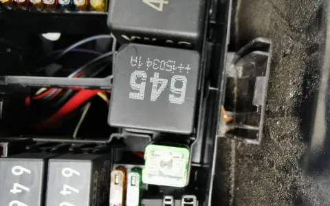 Wnętrze skrzynki z bezpiecznikami i przekaźnikami w Passacie B8. Widoczne przekaźniki z oznaczeniami 645 i 45, a także bezpieczniki.
