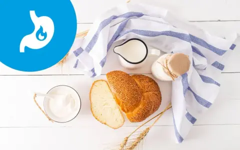 Przykładowy jadłospis przy zapaleniu żołądka: jogurt, mleko, chleb z sezamem i kłosy zbóż.