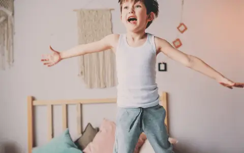 Bambino iperattivo 4 anni cosa fare? Un bimbo salta sul letto, pieno di energia.