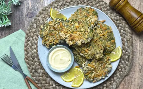 Spinacine fatte in casa croccanti, servite con maionese e spicchi di limone. Un piatto gustoso e salutare.