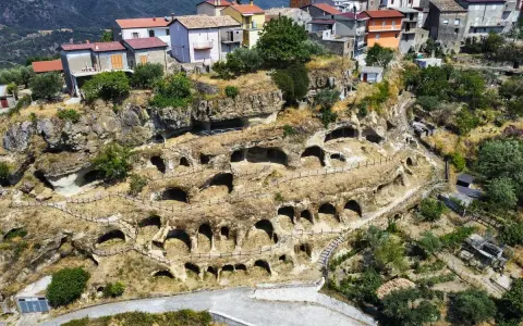 Antiche abitazioni rupestri scavate nella roccia sul Monte Poro, Calabria. Un villaggio arroccato tra le colline verdi.