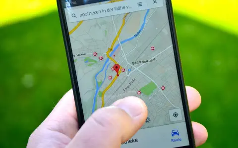 Palec wskazuje na mapę GPS w telefonie, szukając apteki w pobliżu. W samochodzie taka nawigacja to podstawa.