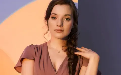 Sanah w The Voice of Poland przesłuchania. Młoda artystka w różowej sukience z warkoczem.