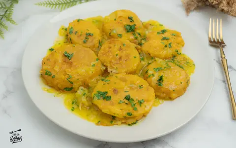 Patatas a la importancia, doradas y tiernas, bañadas en una salsa amarilla con perejil picado. Un plato que demuestra la importancia de las patatas en la cocina.