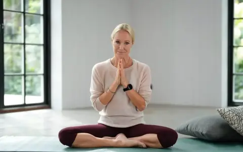 Kvinna i lotusställning på yogamatta, redo för yoga meditation.