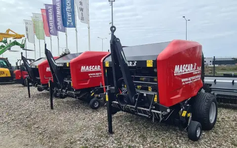 Rzędy czerwonych pras rolujących Mascar, gotowych do pracy na polu.