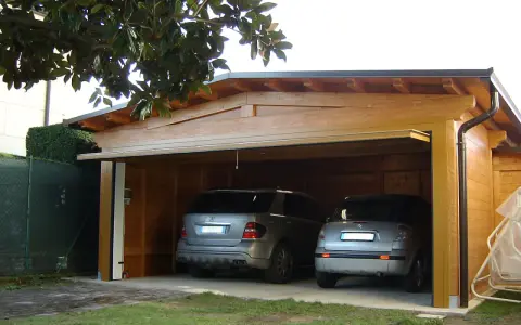 Doppio garage in legno con due auto. La struttura rispetta la normativa garage privati, offrendo un riparo sicuro e funzionale.