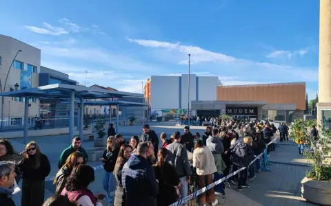 Larga cola de gente esperando para entrar al Mudem, un evento cultural en Murcia.