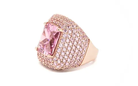 Anello in oro rosa con grande pietra rosa centrale e pavé di zirconi rosa. Il suo significato è legato all'amore e alla femminilità.