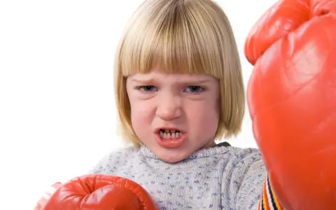 Małe dziecko w rękawicach bokserskich, zaciśnięte zęby. Jak radzić sobie z agresją? Czas na trening!