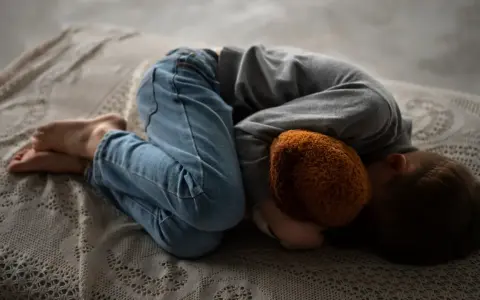 Małe dziecko skulone z pluszakiem, bo **5 letnie dziecko boi się wszystkiego**.