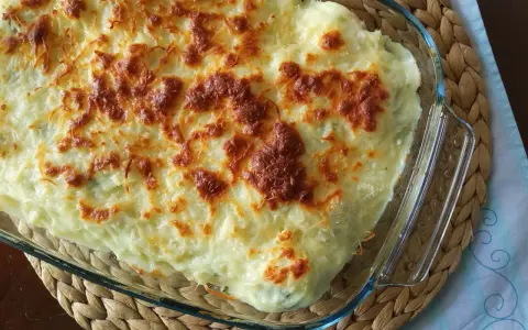 Parmentier de patata gratinado en fuente de cristal, con queso dorado y burbujeante. Un plato reconfortante y delicioso.