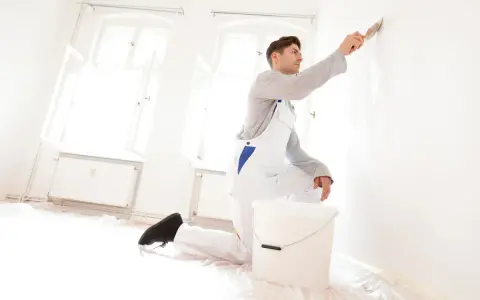 Maler streicht Wand. Kosten für 120 qm Haus streichen? Hier wird renoviert!