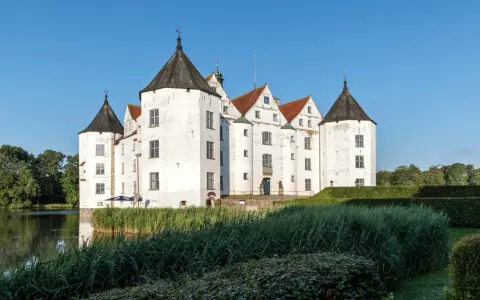 Wasserschloss in Schleswig-Holstein, ideal für die herbstferien 2025. Ein malerisches Schloss mit Türmen und Wassergraben.