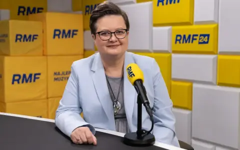 Minister edukacji w jasnej marynarce przed mikrofonem RMF FM.