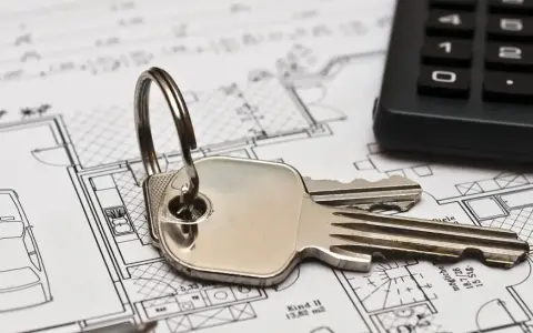 Schlüssel und Taschenrechner liegen auf Bauplänen. Ein Haus mit Garage und Zimmern ist zu sehen. Ideal für Mietrecht Oberhausen.
