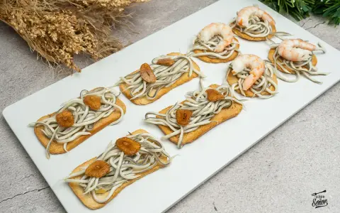 Deliciosas tostas con gulas y gambas, perfectas para tus recetas con gulas para cenar. Un bocado exquisito.