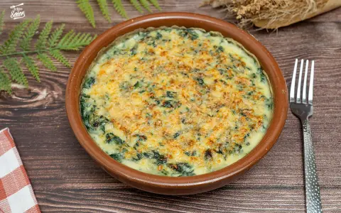 Delicioso plato de espinacas a la crema gratinadas con queso, servido en cazuela de barro. Un bocado cremoso y reconfortante.