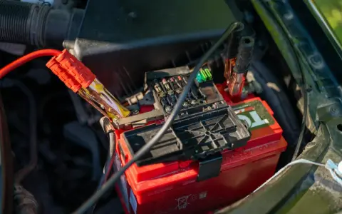 Jump starter cables connected to a car battery. This shows how a jump starter can charge a battery to get your car running again.