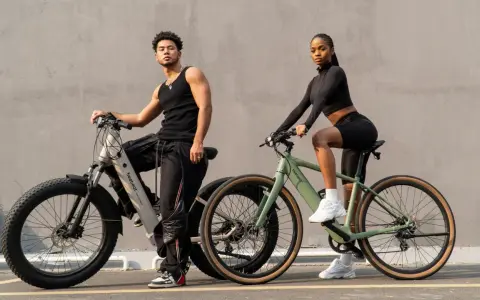 A man and woman pose with their electric hybrid bikes, showcasing a blend of urban style and off-road capability.