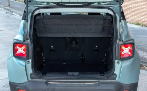 Maletero abierto de un Jeep Renegade color verde menta, mostrando el espacio de carga y la tapa retráctil.