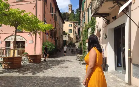 Un vicolo pittoresco con un campanile in lontananza, perfetto per scoprire cosa vedere vicino Rimini.