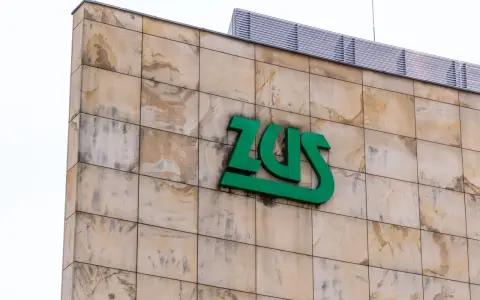 Zielone logo ZUS na beżowej, kamiennej elewacji. Czy chorobowe wlicza się do lat pracy? Zapytaj w ZUS.
