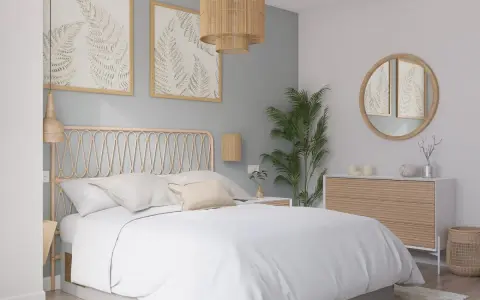 Dormitorio con paredes en colores pastel, cama blanca, cabecero de ratán y cuadros de helechos.