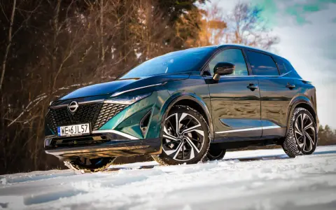 Zielony Nissan Qashqai na śniegu. Wiele osób szuka nissan qashqai opinie, by sprawdzić, jak radzi sobie w trudnych warunkach.