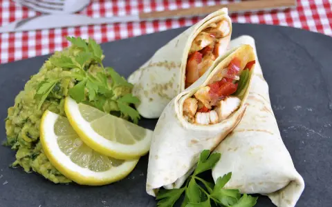 Fajitas de pollo jugosas con guacamole, limón y perejil.