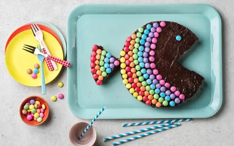 Un délicieux gâteau chocolat en forme de poisson, décoré de bonbons colorés. Parfait pour une fête !