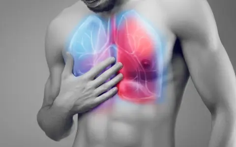 Mężczyzna trzyma rękę na klatce piersiowej, gdzie widoczne są podświetlone płuca. Czerwony obszar sugeruje ból, a niebieski chłód. Pochp co to?