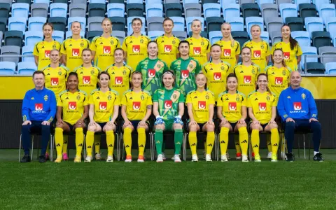 Svenska damlandslaget fotboll poserar för ett lagfoto i sina gula matchställ.