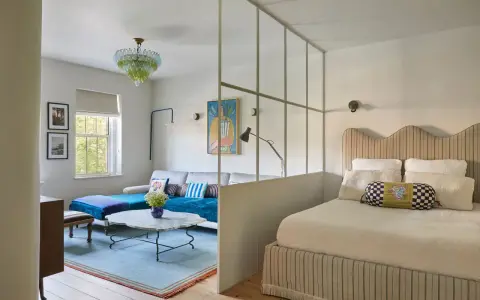 Soluzione creativa per come dividere una camera in due con una sola finestra: zona giorno e zona notte separate da un pannello vetrato.