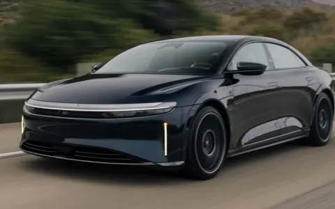 Ciemnoniebieski Lucid Air Sapphire pędzi po drodze, jego aerodynamiczna sylwetka i futurystyczne światła przyciągają wzrok.