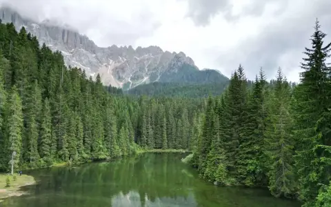 Laghi alpini nella Val di Fassa, circondati da fitti boschi di conifere e imponenti vette rocciose.