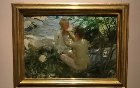Anders Zorn fångar två barn vid en bäck. En flicka klär på en pojke i solljus.