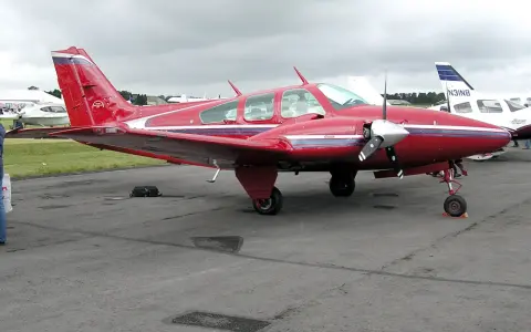 Roter Beechcraft Baron mit zwei Propellern auf dem Flugplatz.