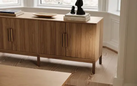 Ett vackert sidobord i trä med böcker och skulpturer på. Perfekt för att styla ditt hem.