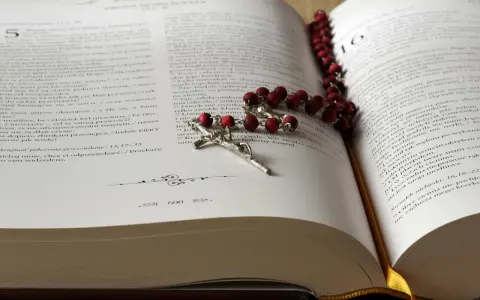 Modlitwa za zmarłą żonę. Różaniec na otwartej księdze, symbol wiary i pamięci.