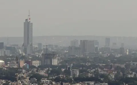 Vista panorámica de Guadalajara con edificios altos y una neblina que afecta la calidad del aire.