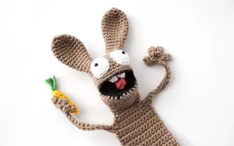 Un divertido conejo amigurumi de crochet, con ojos saltones y una zanahoria en la mano, parece listo para una aventura.
